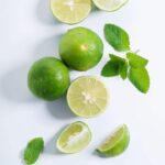 various limes cut into various shapes on a white board