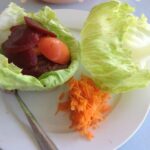 A plate of salad with bunless burger