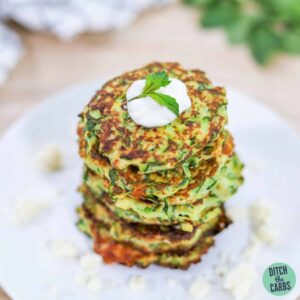 keto zucchini fritters stacked on a white plate