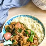 beef rendang served with cauliflower rice in a blue and white dish