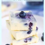 vanilla berry keto cheesecake bars stacked up on a white plate