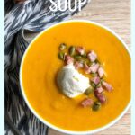 keto pumpkin soup in a white mug garnished with bacon and cream