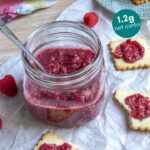 chia seed jam in a mason jar with a spoon with shortbread cookies on the side topped with chia jam