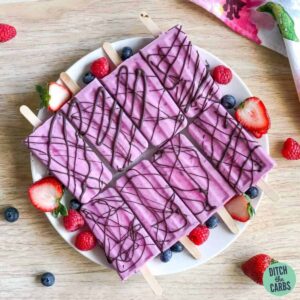 frozen sugar-free popsicles on a plate with fresh berries