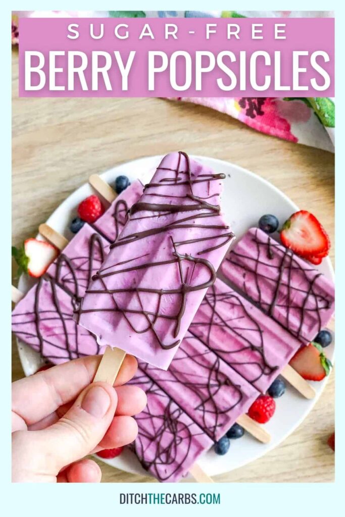 frozen sugar-free popsicles on a plate with fresh berries and drizzled with chocolate