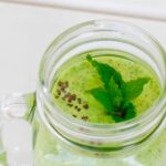 A close up of keto green smoothie garnished with chia seeds and mint leaves