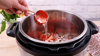 A person holding a pot water into the instant pot to make home-made sugar free ketchup