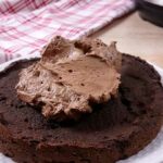 A delicious low carb instant pot chocolate cake being covered with sugarfree chocolate frosting