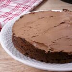 A delicious low carb instant pot chocolate cake being covered with sugarfree chocolate frosting