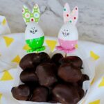 Sugar free chocolate Easter eggs piled on a plate with Easter bunny toys in the background