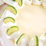 Baked low-carb key lime cheesecake decorated with whipped cream and sliced limes