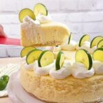 A slice of key lime cheesecake being lifted by the server  