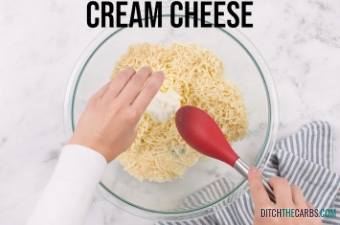 Hands placing cream cheese into a mixing bowl