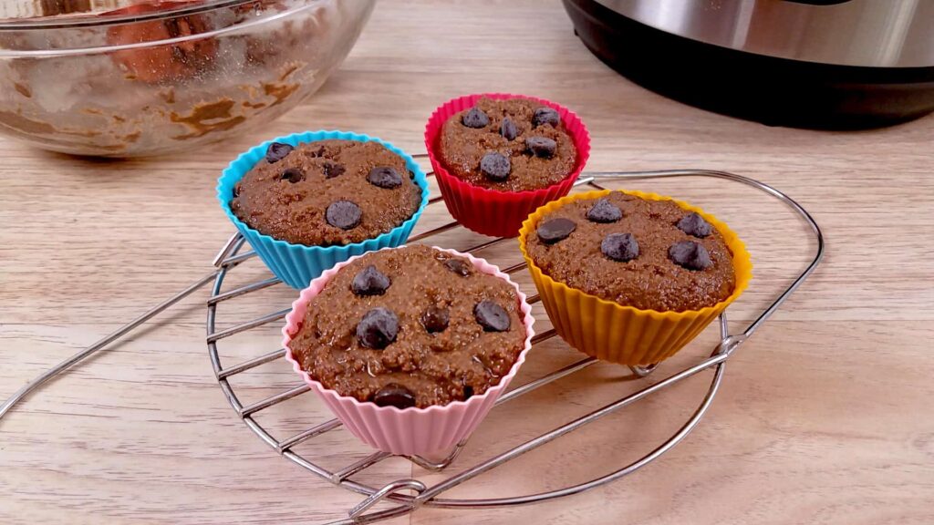 Low carb chocolate muffins and sugarfree chocolate chips sitting on a wire rack