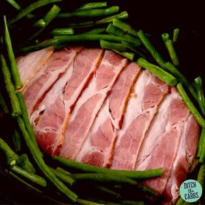 low-carb meatloaf wrapped in bacon sitting in a black slow-cooker