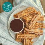 Keto Cinnamon Churro Chaffles served on a plate with chocolate dipping sauce on a wooden background
