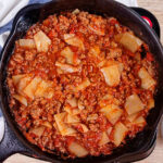 Noodles have been mixed into the meat sauce for low-carb skillet lasagna in a cast iron skillet.