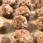 keto meatballs baked and in rows served in a glass baking pan.
