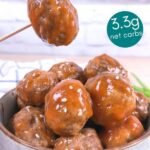 Sweet and sour keto meatballs being served in a blue stone bowl. One meatball is being lifted with a toothpick.