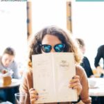 woman with glasses reading menu