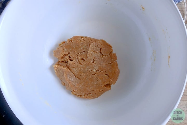A white mixing bowl with peanut butter cookie dough