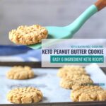 peanut butter cookie being lifted with a blue spatula