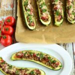 cooked zucchini taco boats on baking parchment and served with salsa and cheese