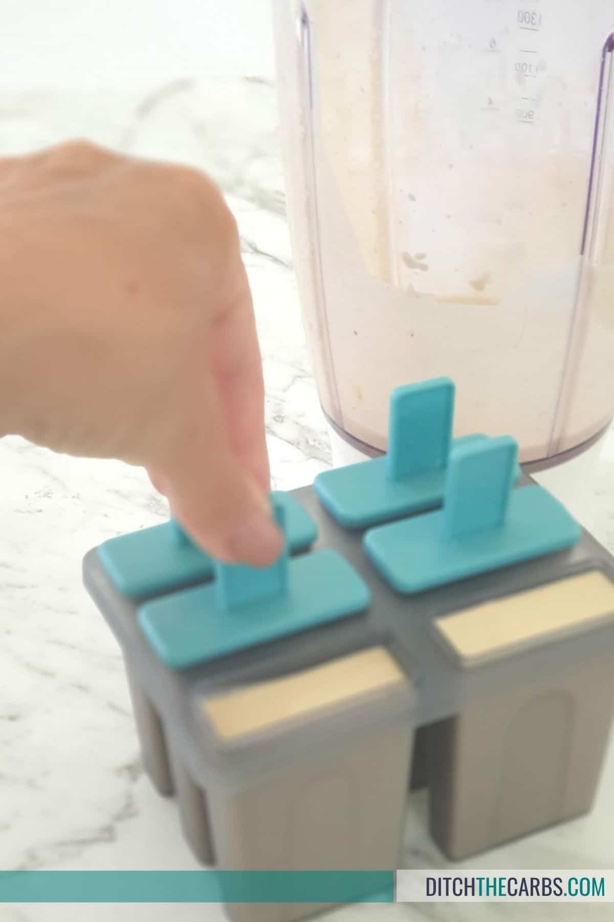 pouring ice cream into popsicle moulds