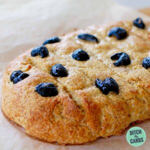 baked focaccia bread on a wooden bread board