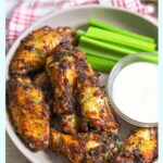 Air Fryer Chicken Wings Tossed in Keto Dry Rub on a plate with a side of keto ranch and celery.