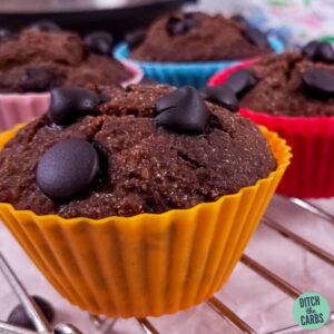 Low carb chocolate muffins and sugarfree chocolate chips sitting on a wire rack