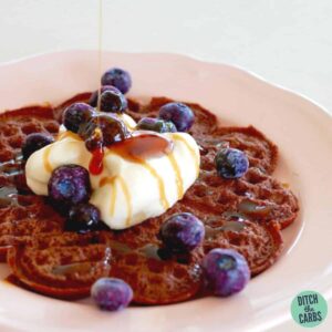 Chocolate waffle being poured with maple syrup