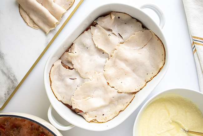 Adding sliced turkey to the low-carb lasagna