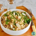 A bowl of cauliflower couscous the wooden board with an antique fork