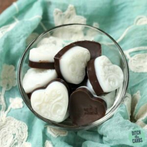 Sugar-free peppermint fat bombs sitting in a glass dish