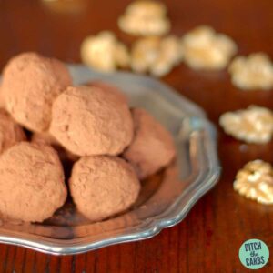 A tray of brandy truffles with walnuts on a silver antique plate