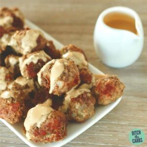 A plate of food and a cup mushroom sauce with keto meatballs