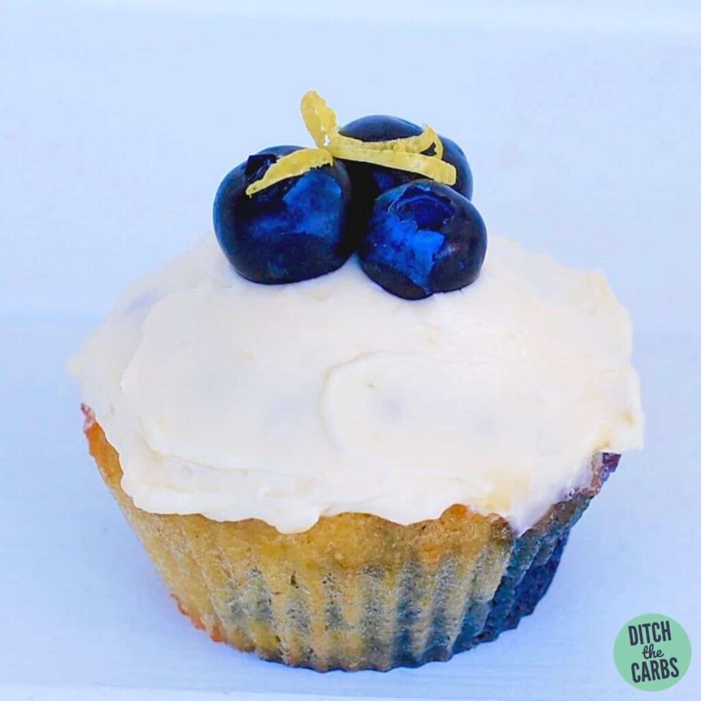 Close up of a low-carb cupcake frosted and a blueberry on top