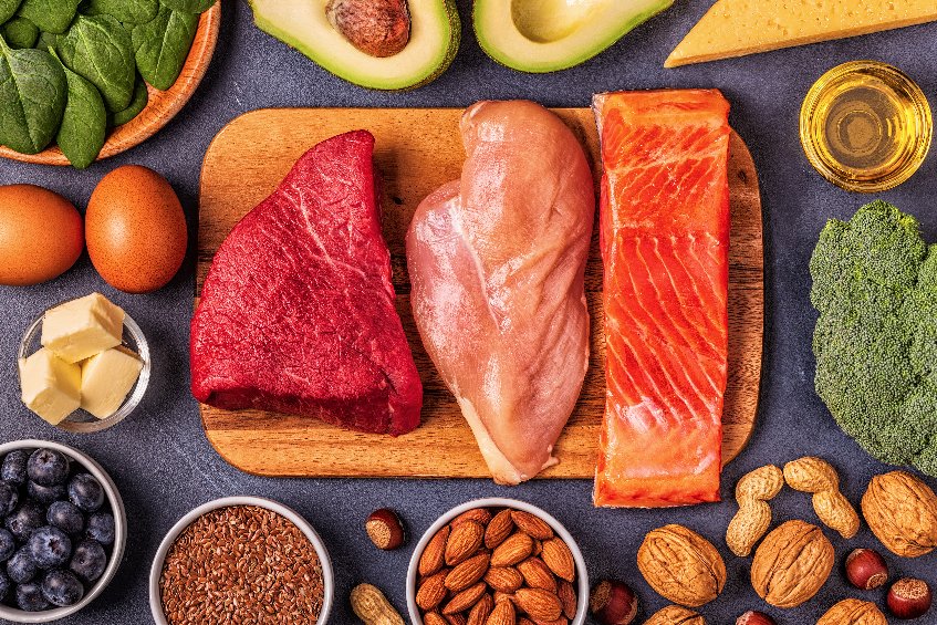 A plate of meats, nuts, fruits and veggies to describe the advantages of being a meat eater.