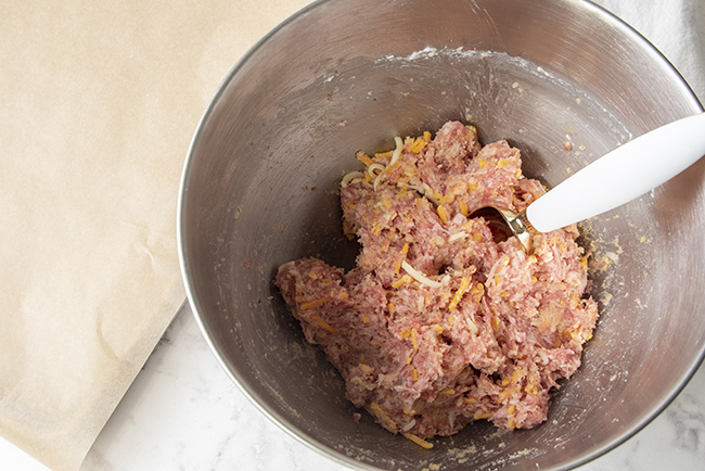 mixing up ingredients for sausage balls in a stand mixer