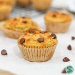 Keto chocolate chips muffins spread out over parchment paper.