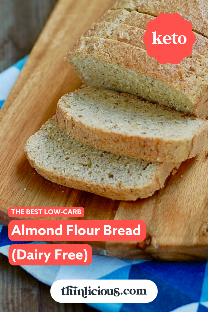 low-carb almond flour bread sliced and buttered on a wooden chopping board