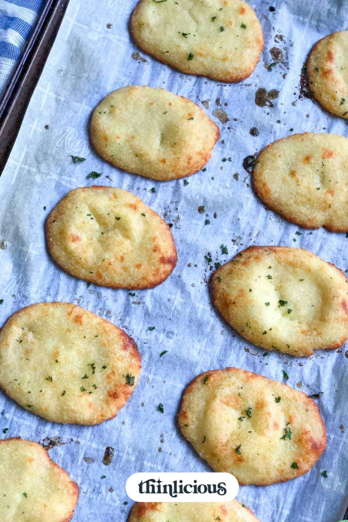 Brushing homemade naan with garlic butter and fresh parsley